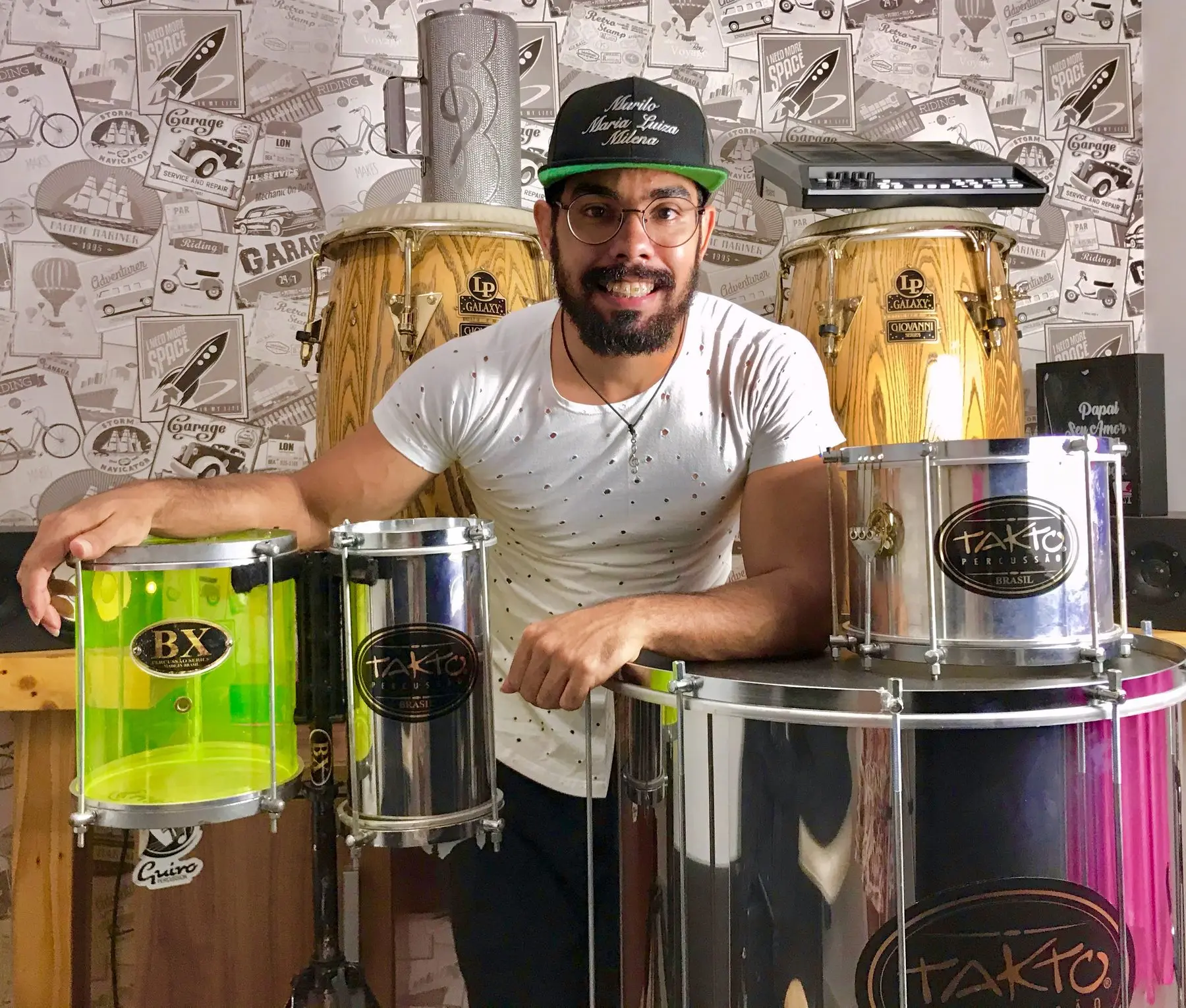 Murilo Pontes sorrindo atrás da bancada de percussão, no estúdio.
